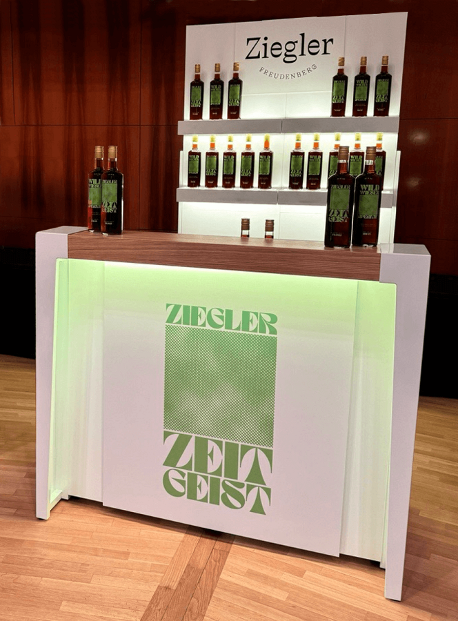 Weiße Bar mit Bartop aus Holz und Markenschild.