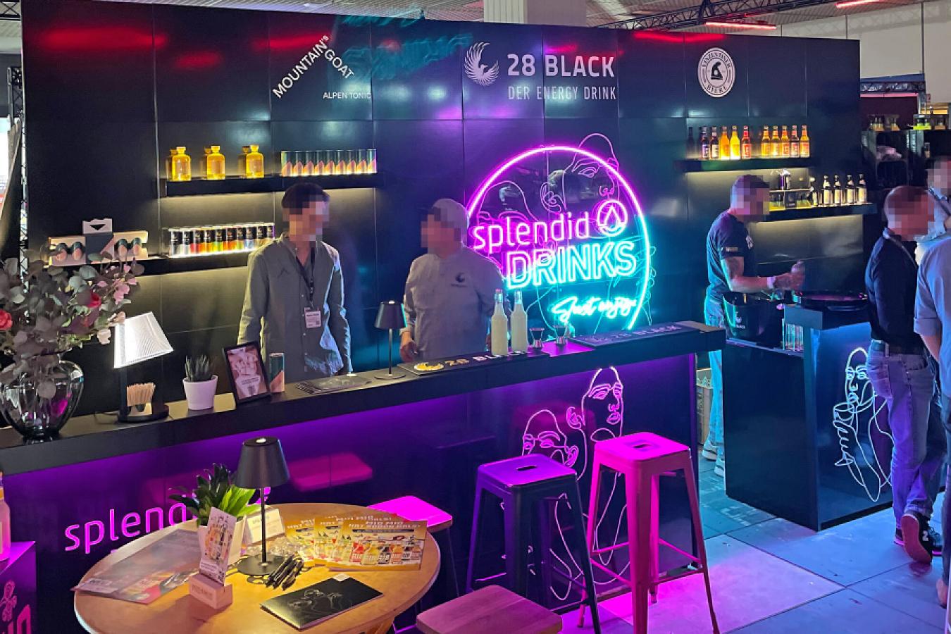 Schwarze Messebar mit Rückwand für beleuchtete Flaschenpräsentation.