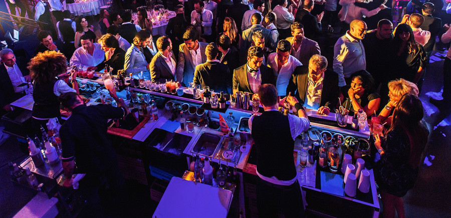 Cocktail bar in the middle of an event location with many people.