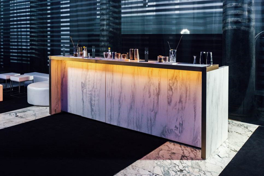 Portable cocktail bar in marble look, brass applications and LED lighting in noble environment.
